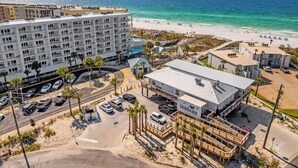 A beachfront hotel with multiple floors, a parking lot, and a view of the ocean. - Seacrest Beachfront 2BR | Angled Gulf View + Pools (Fort Walton Beach)