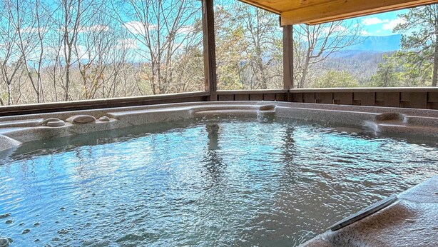 Un bain à remous avec vue sur les montagnes et les arbres.