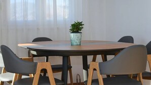 A round table with a potted plant in the center, surrounded by six chairs with wooden frames and dark cushions. - Wonderful quiet beach location 5 km from Trogir, swimming pool, sea view (Okrug Gornji)
