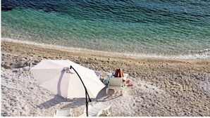 A beach with a white umbrella and lounge chairs. - Wonderful quiet beach location 5 km from Trogir, swimming pool, sea view (Okrug Gornji)