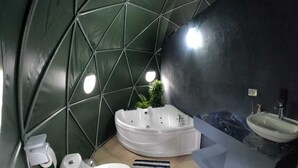 A modern bathroom with a freestanding bathtub, a sink, and a toilet. - Domo Geodésico 01 (Florencia)