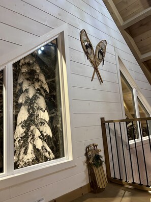 Une pièce dotée d’une grande fenêtre, d’un plafond en bois et d’un élément décoratif mural.