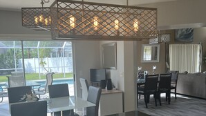 Eine moderne Küche mit schwarzer Arbeitsplatte, Holzschränken und einer Pendelleuchte.