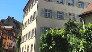 A multi-story building with a classic architectural style, featuring a symmetrical facade with evenly spaced windows and shutters.