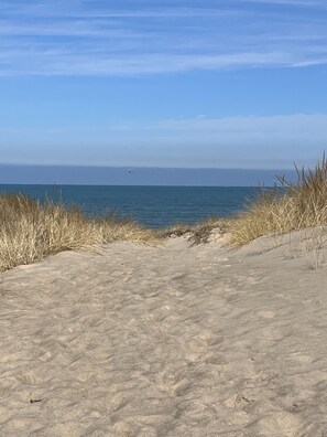 A sandy beach with a clear view of the ocean.