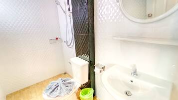 A bathroom with a toilet, a sink, and a shower.