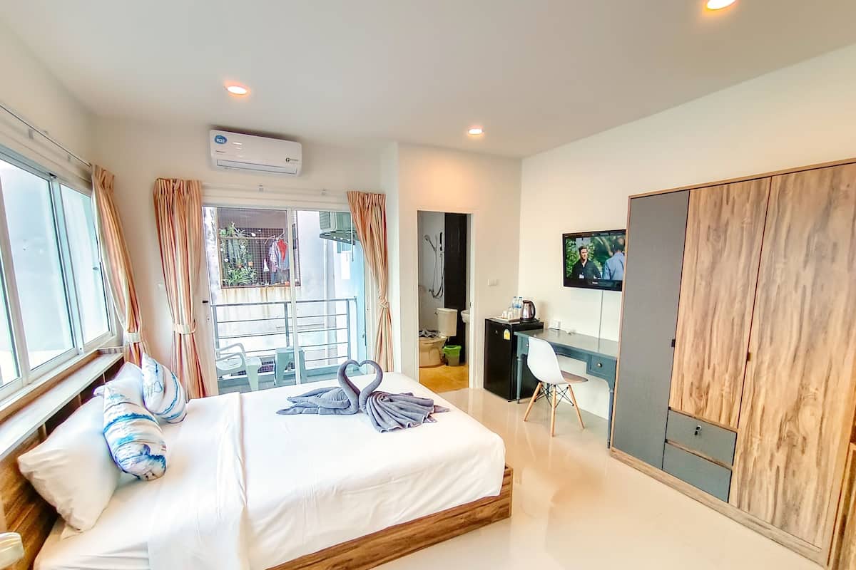 Une chambre d’hôtel moderne équipée d’un grand lit, d’un bureau avec une chaise, d’une télévision et d’une armoire.