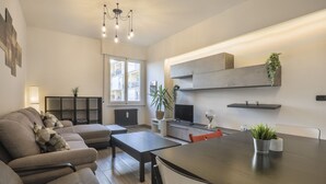 A modern living room with a sofa, coffee table, TV, and dining table. - Brizio's Flat - Sweet Dreams in Florence (Firenze)