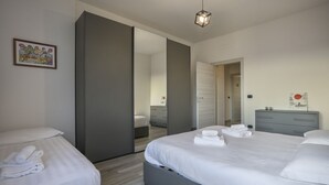 A modern hotel room with a large bed, a bedside table, a wardrobe, and a mirror. - Brizio's Flat - Sweet Dreams in Florence (Firenze)