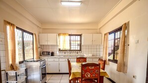 Una cucina compatta con zona pranzo, dotata di forno a microonde, piano cottura e mobili.