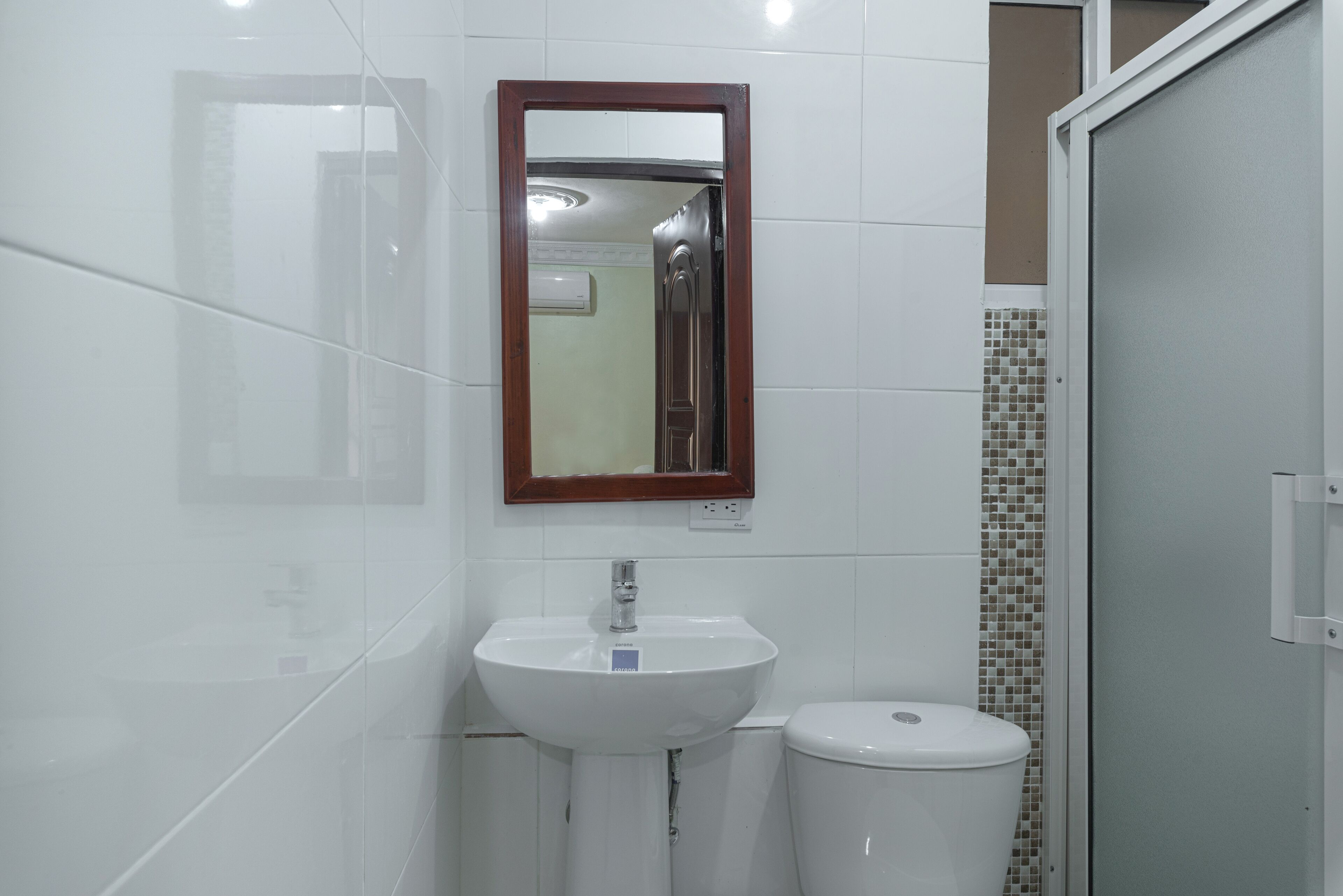 Un baño con un lavabo blanco, un espejo y un inodoro.