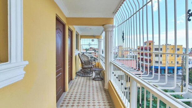 A balcony with a tiled floor, a chair, and a table.