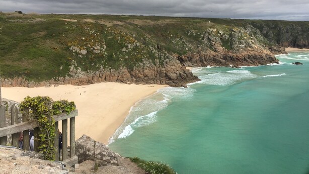 A coastal landscape with a sandy beach, rocky cliffs, and a wooden structure with a view of the ocean. - 1 bed-cottage-Parking-Patio-close to coasts (Launceston)