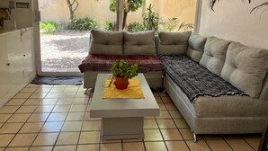 Un salon avec un canapé, une table basse et une plante en pot.