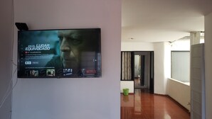 Un couloir dans lequel est fixé un téléviseur à écran plat au mur, et qui affiche une affiche de film.