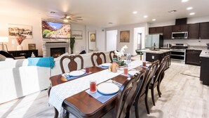 A modern kitchen with dark cabinets, a microwave, and a stove. - Family Pool Home – Saltwater Pool & Fire Pit – 2 King Suites – Sleeps 12 (Elk Grove)