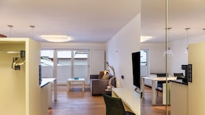 A modern living space with a kitchen area, dining table, and seating. - Apartment "Haus Excelsior Top 30" with Mountain View, Balcony & Wi-Fi (Seefeld in Tirol)