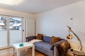 A modern living room with a sofa, a coffee table, and a lamp.