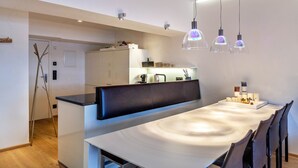 A modern kitchen with a dining area, white cabinetry, and pendant lighting. - Apartment "Haus Excelsior Top 38" with Mountain View, Balcony & Wi-Fi (Seefeld in Tirol)