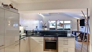 A modern kitchen with stainless steel appliances, white cabinetry, and pendant lighting. - Apartment "Haus Excelsior Top 38" with Mountain View, Balcony & Wi-Fi (Seefeld in Tirol)