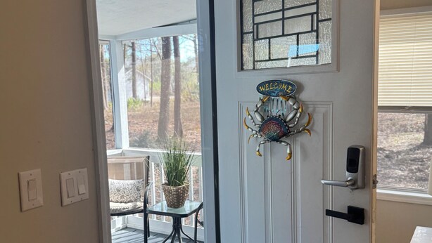 A door with a welcome sign, a glass panel, and a doorbell.