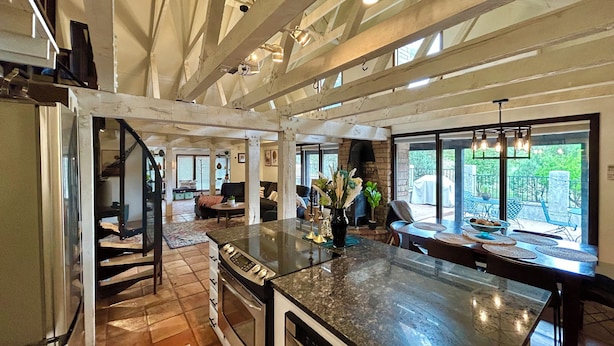 A spacious kitchen with a large island, built-in oven, and a dining area with a view of the outdoors. - Private Forest Lodge w/Game House, Spa, mins to DT (Prescott)