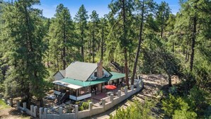 A lodge with a green roof, surrounded by tall pine trees. - Private Forest Lodge w/Game House, Spa, mins to DT (Prescott)