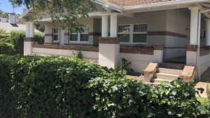 A house with a covered porch, a chimney, and a brick foundation. - Poppy’s Place, a beautiful family & pet friendly1920’s bungalow.  (Angaston)