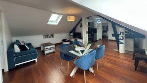 Eine moderne Loft-Wohnung mit Essbereich, einer Couch, einer Küchenzeile und einer Treppe.