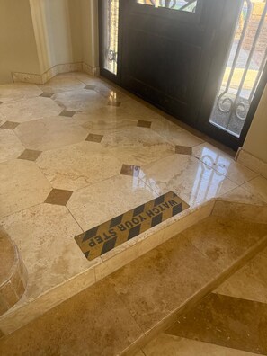 A tiled floor with a warning sign.