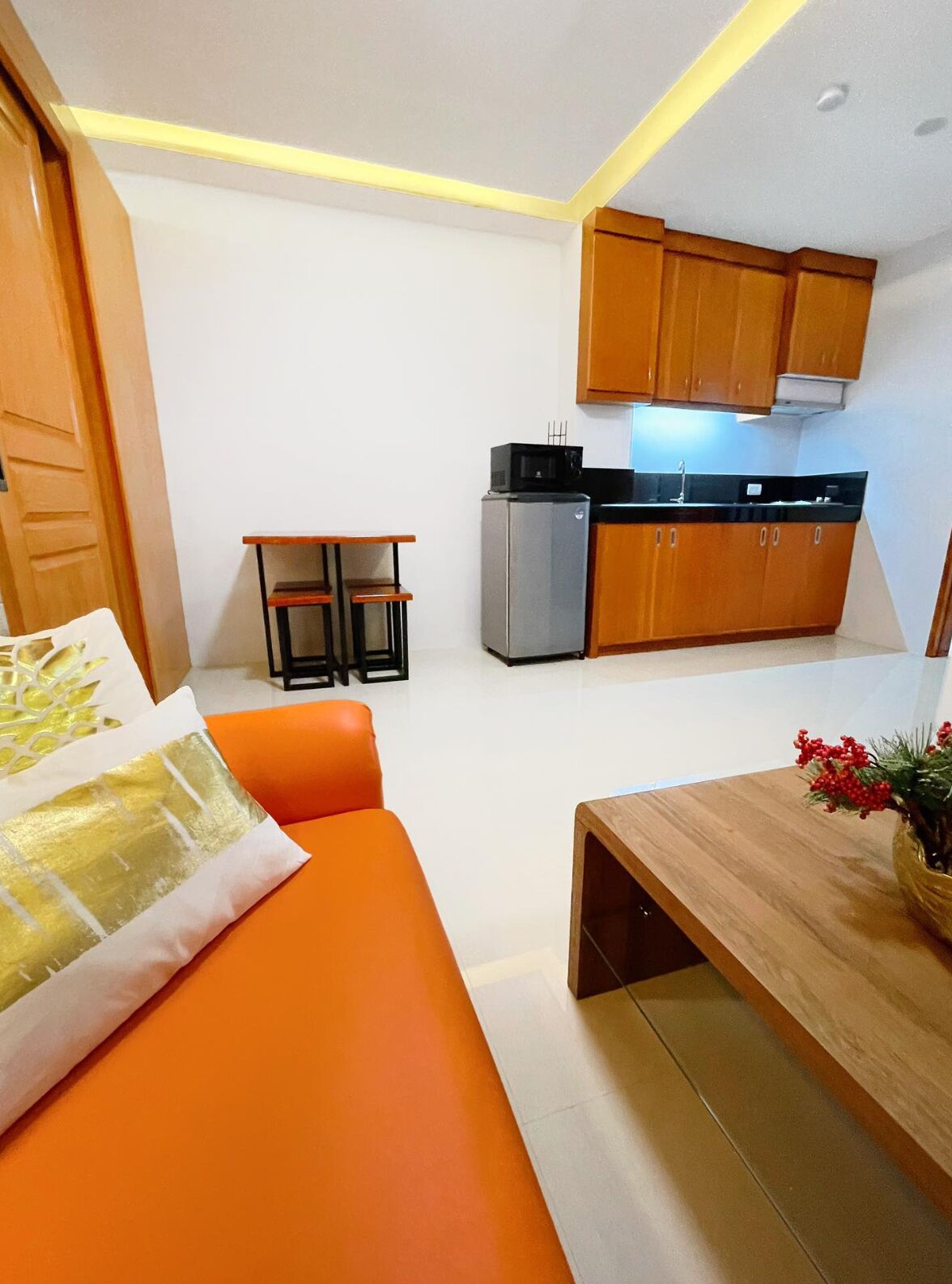 A compact living space with a kitchenette, a small dining table, and a sofa.