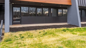 Een modern gebouw met grote ramen, een houten schuine dak en een betonnen fundering.