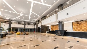 A spacious lobby with a polished floor, a reception desk, and a modern ceiling design. - Raia Hotel & Convention Centre Kuching (Kuching)