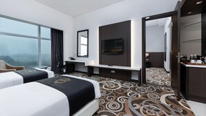 A hotel room with two beds, a TV, a desk, and a view of the city. - Raia Hotel & Convention Centre Kuching (Kuching)