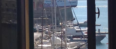 A view of a harbor with boats and a large ship docked.