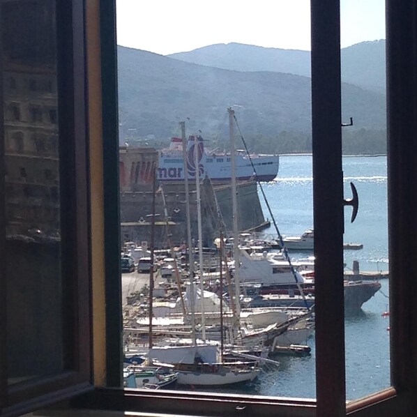 Vista de un puerto con barcos y un gran barco amarrado.