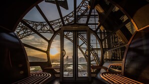 A circular observation deck with a panoramic view of a cityscape and a river. - Epic Tower - Studio City Macau (Cotai)