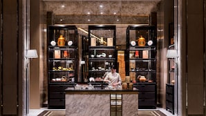 A well-lit, modern kitchen with marble countertops and black shelving filled with kitchenware and decorative items. - Epic Tower - Studio City Macau (Cotai)