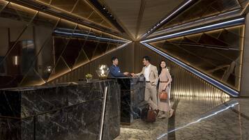 A modern reception area with a marble reception desk, geometric lighting, and a polished floor.