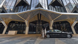 A modern building with a glass facade and a geometric entrance canopy. - Epic Tower - Studio City Macau (Cotai)