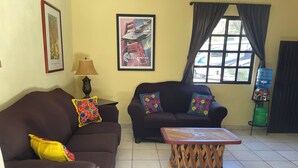 A living room with two sofas, a coffee table, a lamp, and a water dispenser. - Casa arroyo at Bajazul just steps of waterfront and downtown (Loreto)