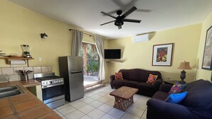 A compact living space with a kitchen, dining area, and seating area. It includes a refrigerator, stove, and a ceiling fan. - Casa arroyo at Bajazul just steps of waterfront and downtown (Loreto)