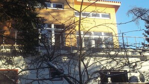 Un immeuble de deux étages avec une façade jaune et un toit rouge.