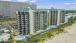 Un hôtel de grande hauteur doté de nombreux balcons, d’une piscine et offrant une vue sur la plage.