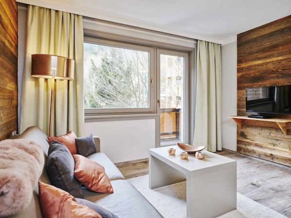 A modern living room with a sofa, coffee table, and TV.