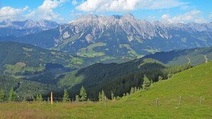 A mountainous landscape with a clear sky and a view of a mountain range.