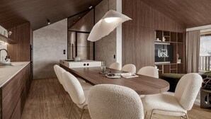 Eine moderne Küche mit Holztisch, weißen Stühlen und einer großen Pendelleuchte.