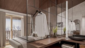 Une chambre moderne avec un grand lit, une table de chevet, un miroir et une vue sur un paysage enneigé.