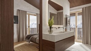 Une salle de bain moderne avec un grand miroir, un lavabo et un espace douche.