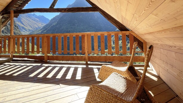 Eine Holzterrasse mit Blick auf die Berge.
